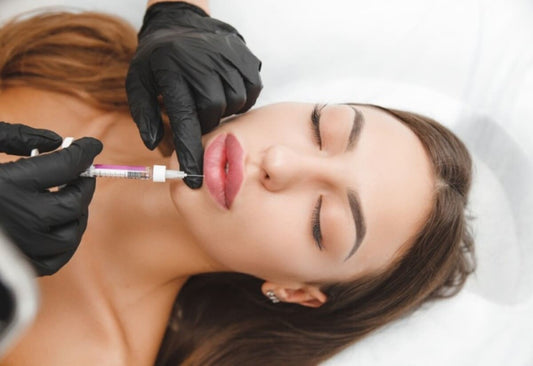pacienta cu ochii inchisi, primeste injectia cu acid hialuronic